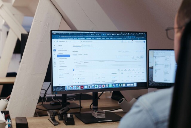 Beeld van een werkplek waarop een Google Ads-account geopend is op een computerscherm, met grafieken en campagneresultaten zichtbaar.